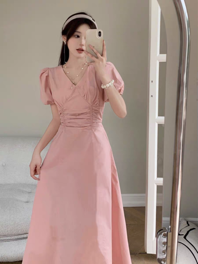 Vestido rosa pliegues y mangas abullonadas .