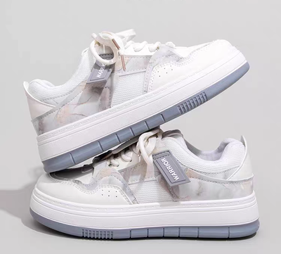 Zapatillas de diseño moderno con base elevada y detalles suaves color celeste y gris.