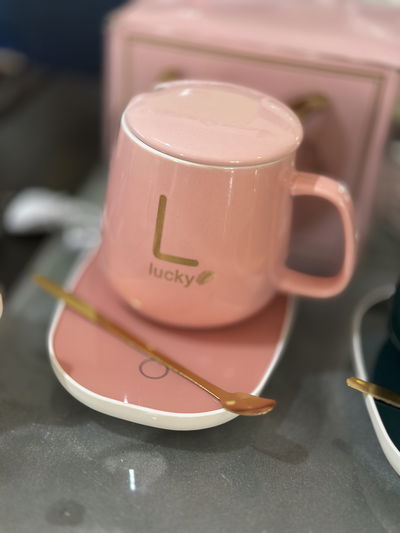 Taza rosa con tapa, cucharita y calentador eléctrico rosa y verde 