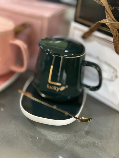 Taza con tapa verde, cucharita y calentador eléctrico rosa y verde 