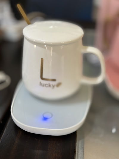 Taza blanca con tapa , cucharita y calentador eléctrico rosa y verde 