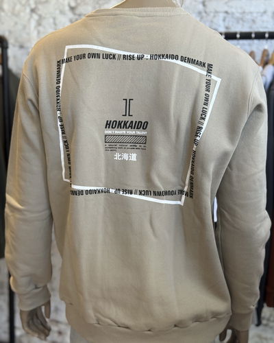 Buzo frisado beige estampa trasera