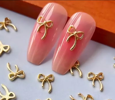 Dije moño metal dorado aplique