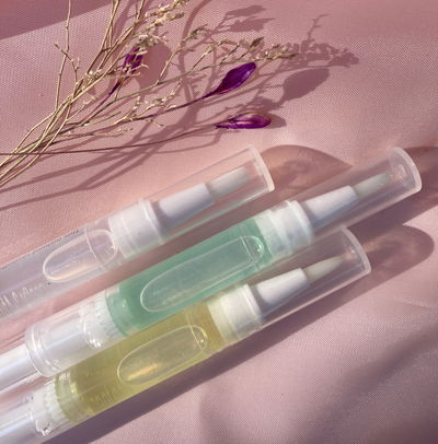 Aceite para cutículas con pincel aplicador.