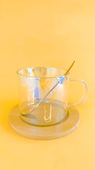 Taza de vidrio holográfico con plato de bambú y cucharita