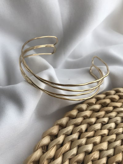 Brazalete cruzado acero dorado