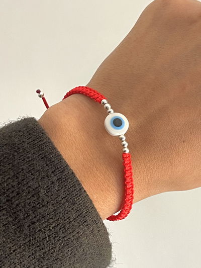 Pulsera de hilo tejida con bolitas de plata y ojo turco azul 
