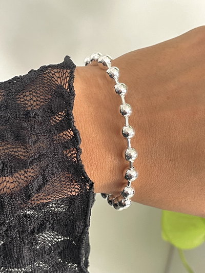 Pulsera bolitas lisas con tubitos .