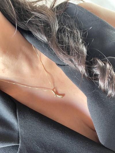 Cadena con dije en forma de dos gotas afinadas .