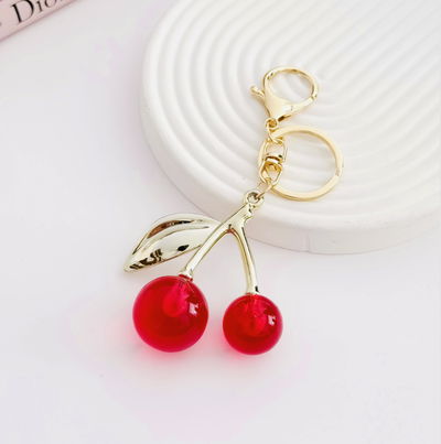 Llavero Bag Charms cerezas fucsias con dorado 