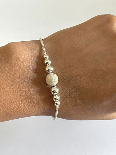 Pulsera con 7 bolitas ( 1 satinada 6 lisas ) 