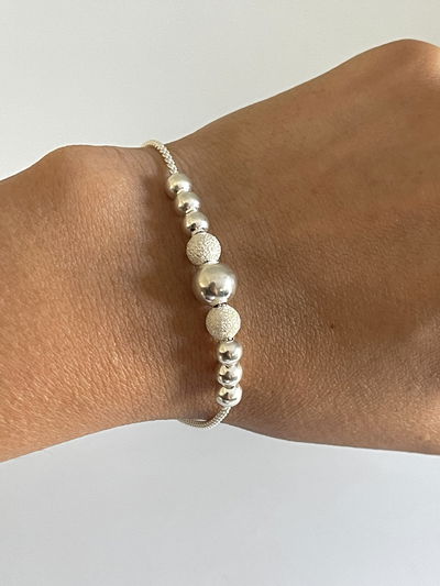 Pulsera con 9 bolitas satinadas y lisas 