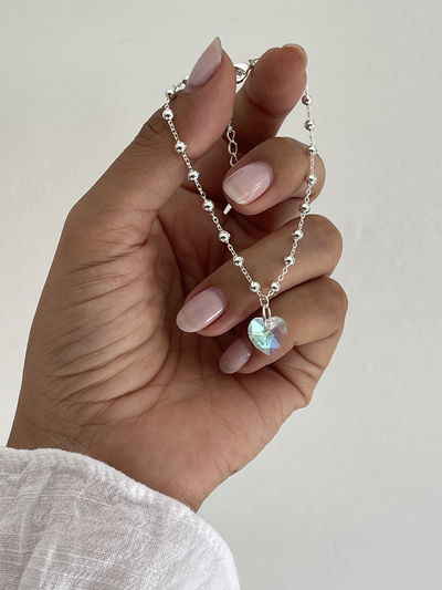 Pulsera con cadena y bolitas intercaladas con dije símil cristal en forma de corazón 