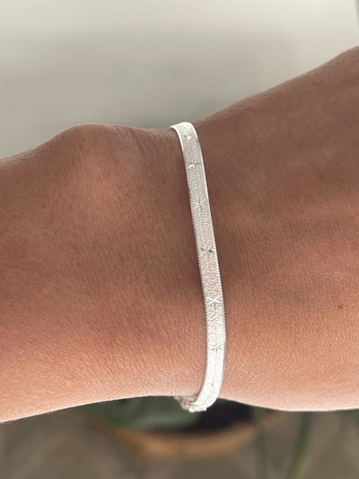 Pulsera plana satinada con detalles de estrellas