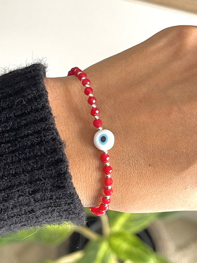 Pulsera hilo rojo con cristales bolitas y ojo turco .