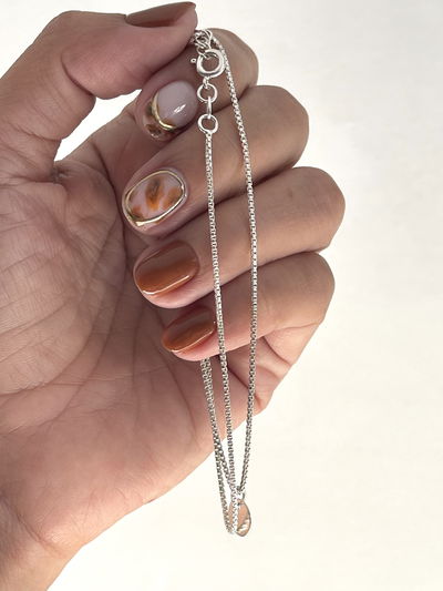 Cadena veneciana con dije pequeño redondo . 