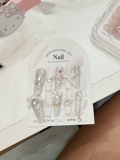 Uñas press on blancas y plateadas con lazo 