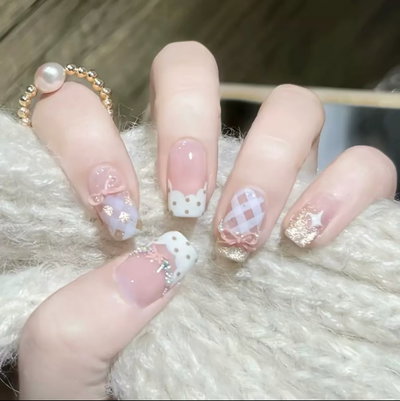 Uñas press on cortas brillo dorado con moño rosa 