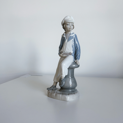 Lladro niño  marinero sentado junto a su barco