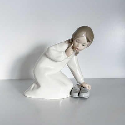 Lladro niña agachada junto a zapatos