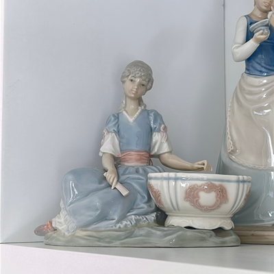 Lladro niña sentada con un cuenco. Es conocida como niña joyera