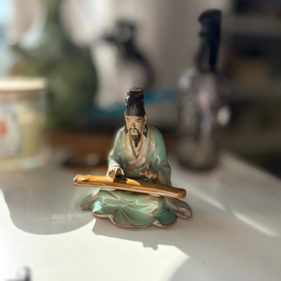 Figura oriental de musico tocando un instrumento
