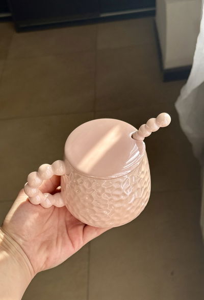 Taza rosa con tapa y cuchara