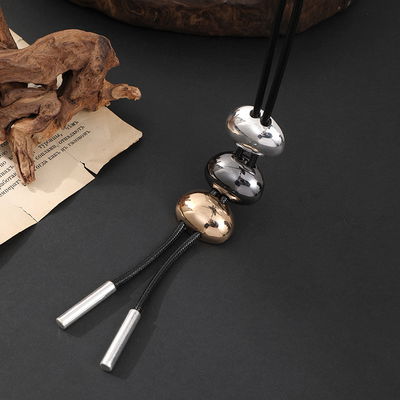 Collar largo de cordón negro con dije tricolor metalizado